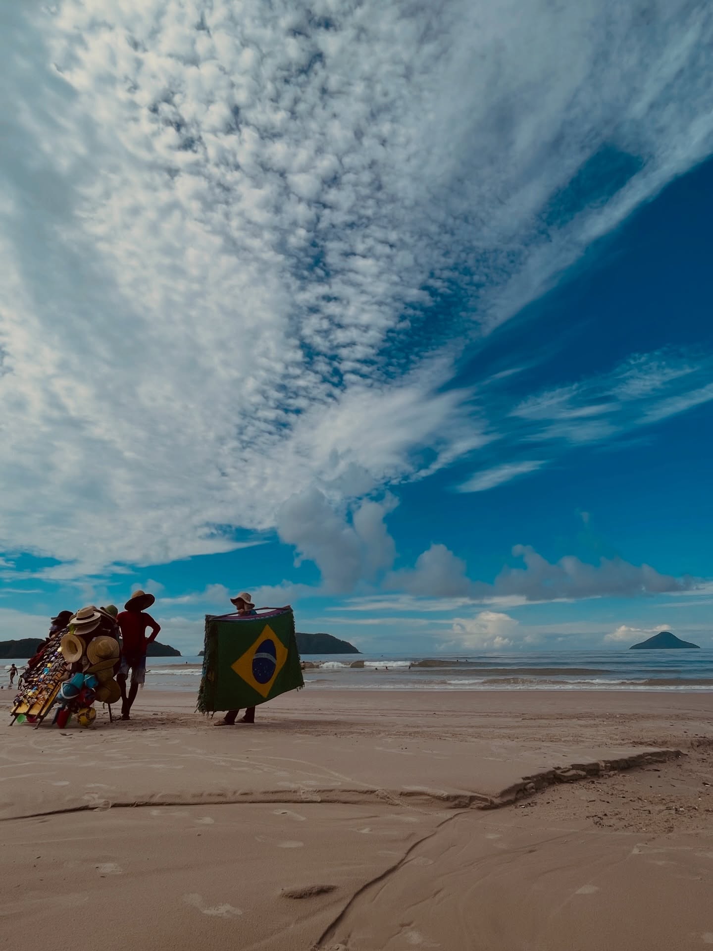 Beach vendors beneath a cloud-filled blue sky